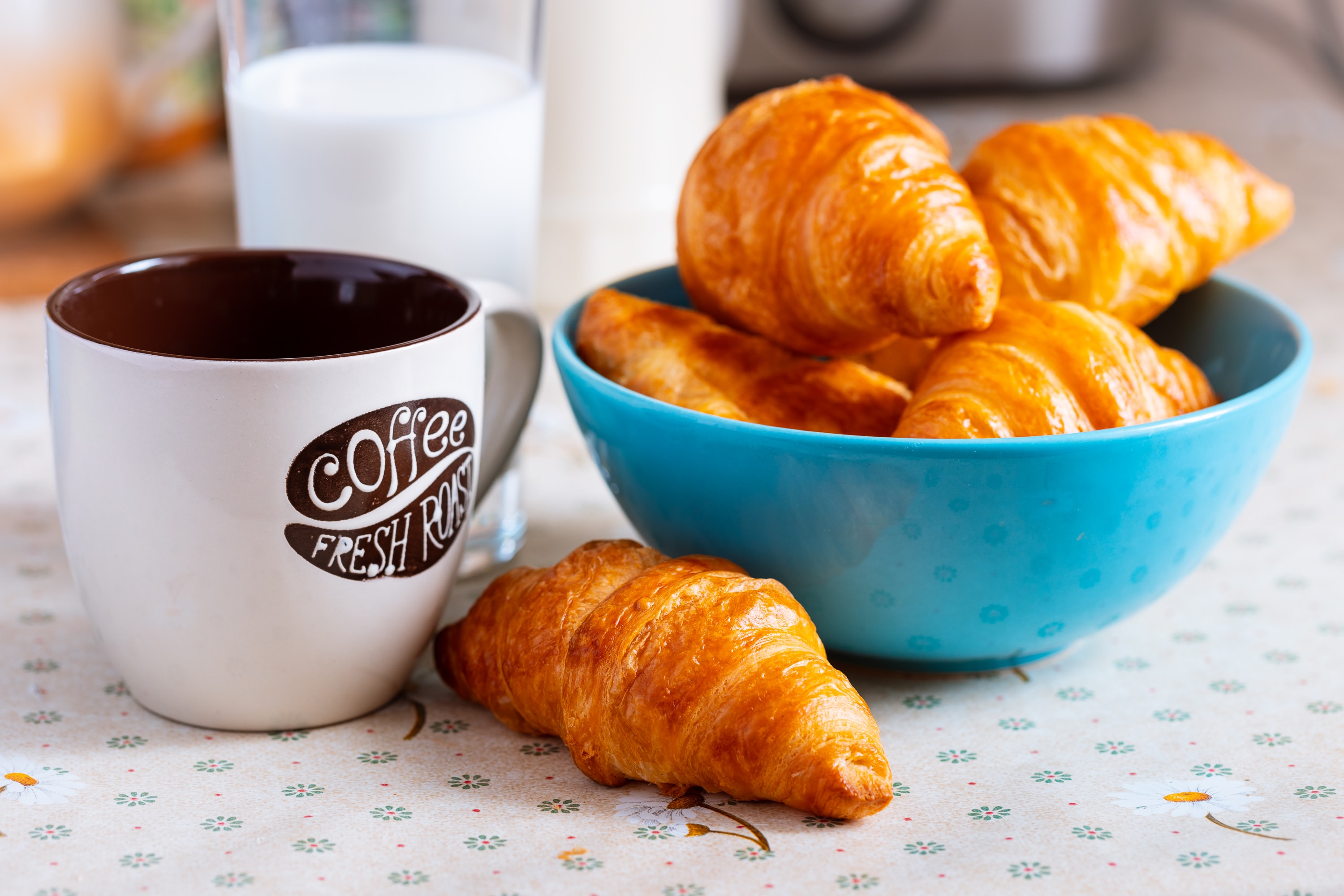 A bowl of croissants with a mug of coffee